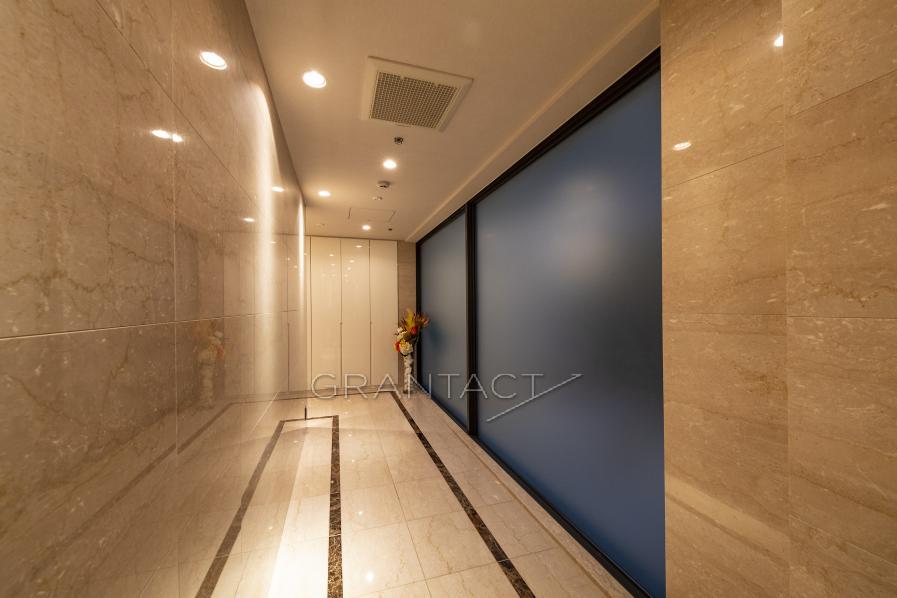 廊下部分　大理石ボーダー貼り（マロンブラウン）と間接照明のデザインにより落ち着きのある雰囲気に。